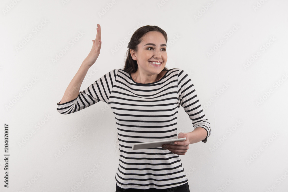 Body language. Nice emotional woman gesticulating while holding her tablet Body language. Nice emotional woman gesticulating while holding her tablet