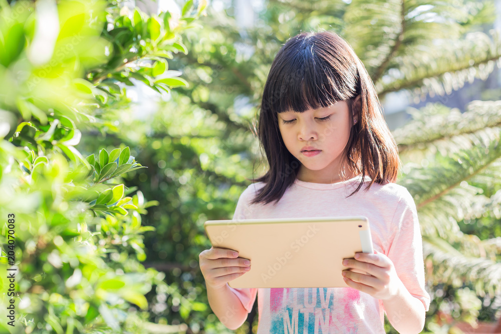 Asian kid girl using tablet for internet communication. Asian kid girl using tablet for internet communication.