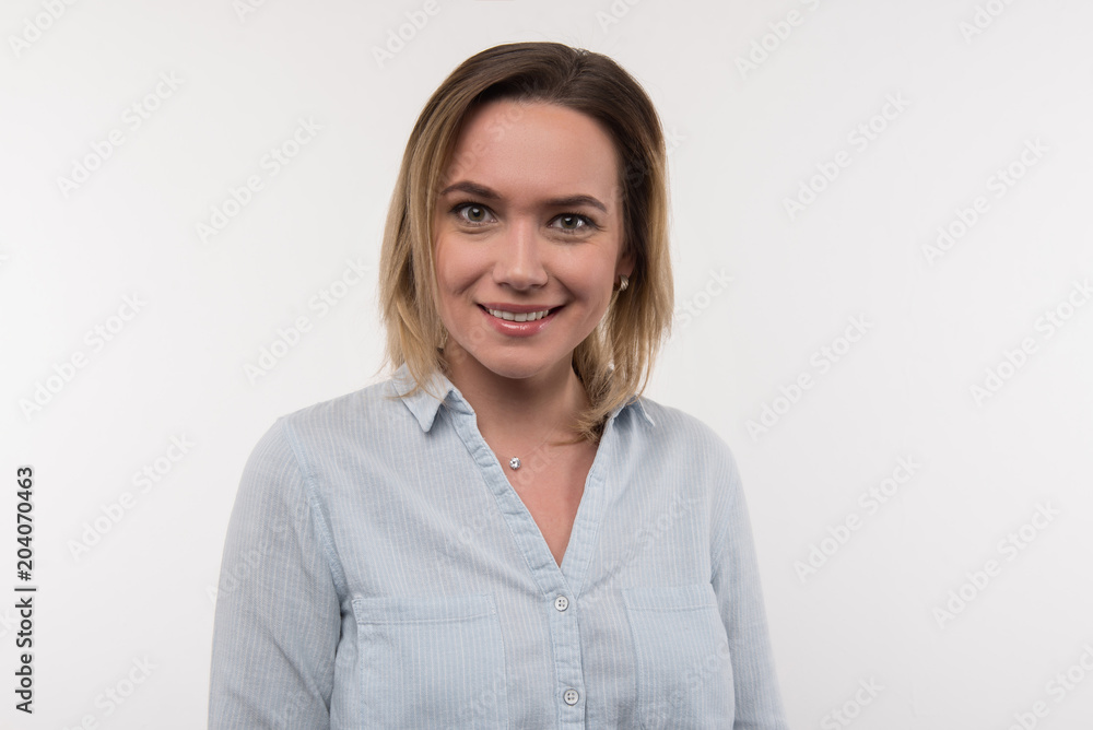 Optimistic mood. Portrait of a delighted optimistic woman smiling while looking at you Optimistic mood. Portrait of a delighted optimistic woman smiling while looking at you