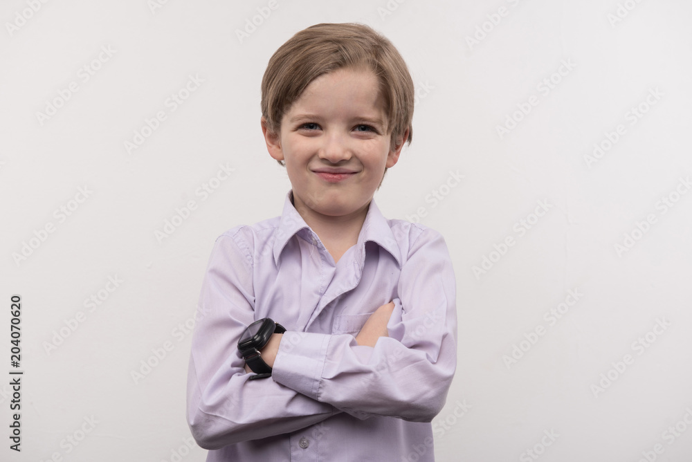 New gadget. Happy cute boy standing cross handed while wearing a smartwatch New gadget. Happy cute boy standing cross handed while wearing a smartwatch