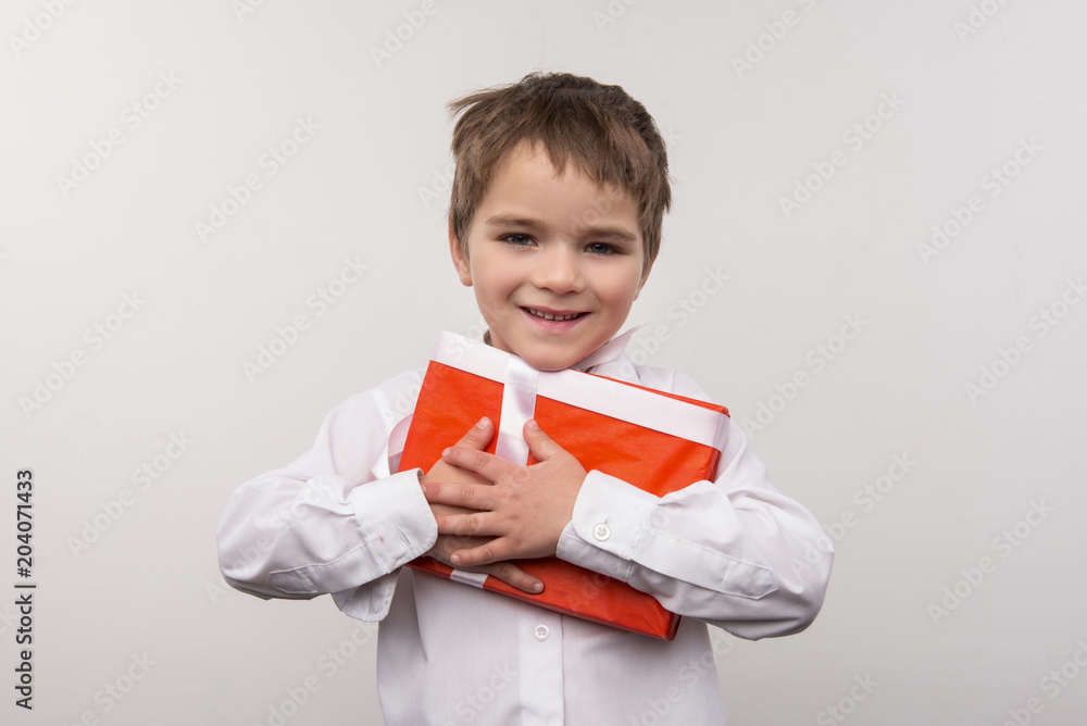 Christmas gifts. Cute small boy hugging a present while being happy about Christmas Christmas gifts. Cute small boy hugging a present while being happy about Christmas