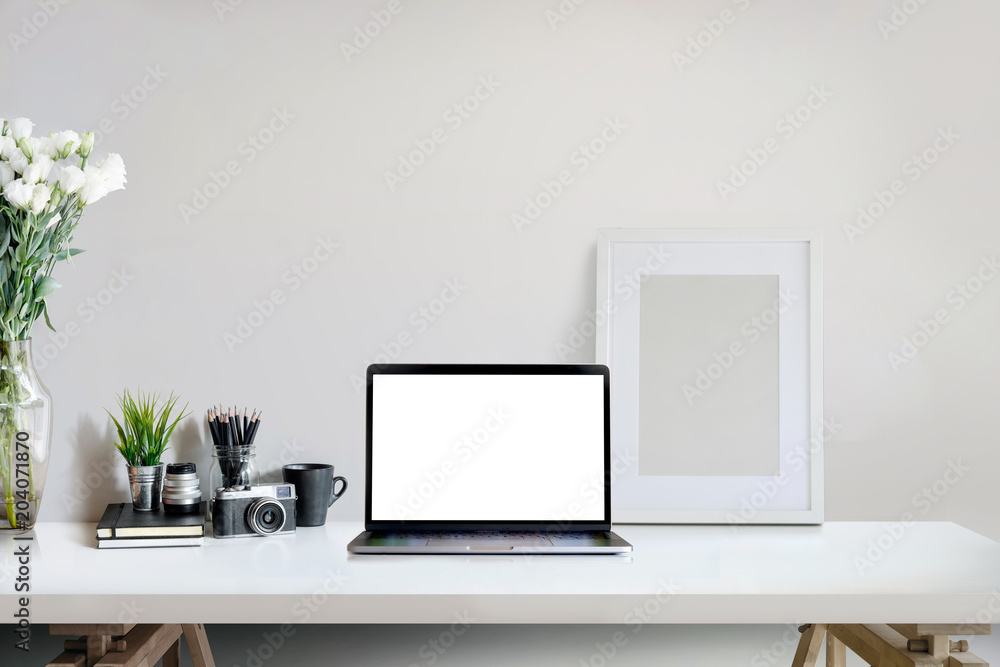 Stylish creative workspace with laptop computer and mockup poster on home or studio. Stylish creative workspace with laptop computer and mockup poster on home or studio.