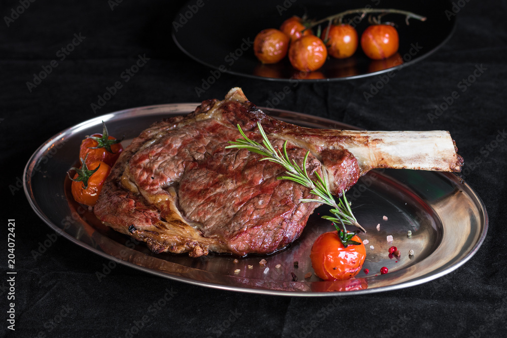 Tomahawk Rib Rack Foto de Single tomahawk rib steak on silver dish next to roasted cherry ...