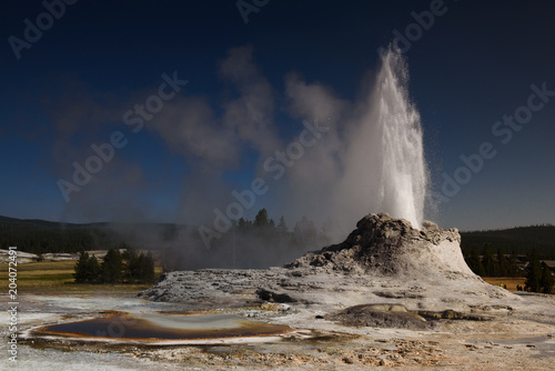 Erupting castle geyser and tortoise shell pool in Yellowstone national park
