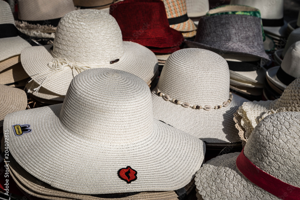 Gestapelte weiße Hüte auf dem Wochenmarkt