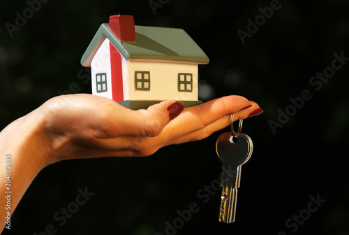 Hand with keys and toy house