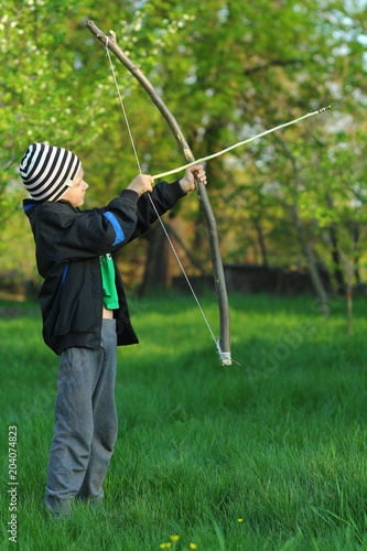 Boy shooting with a hand made bow and arrow. Archery