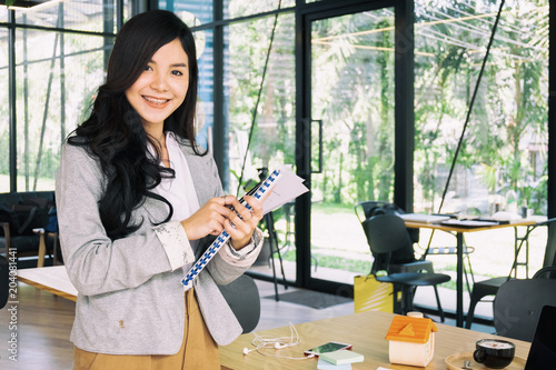 Young businesswoman standing with document near the office window, business concept