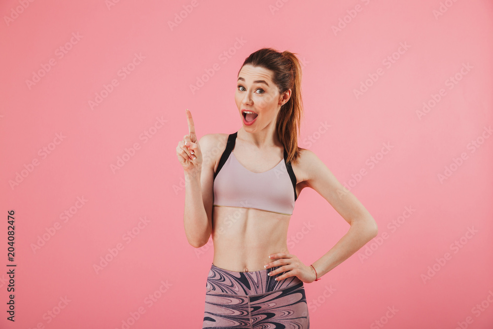 Cheerful sportswoman posing with arm on hip while having idea Cheerful sportswoman posing with arm on hip while having idea