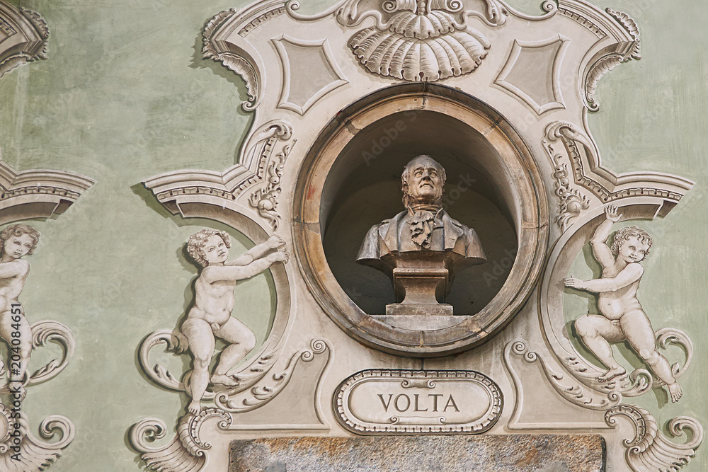Vintage sculpture portrait of Alessandro Volta, an Italian physicist, chemist, and a pioneer of electricity and power on a facade of an old building in Bellinzona, Switzerland