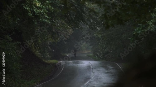 Shot of the Professional Motocross Driver Riding on His FMX Motorcycle on the rear wheel in the rain 4k