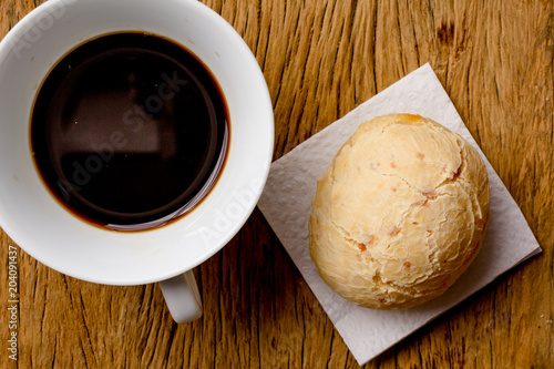 Pao de Queijo is a cheese bread ball from Brazil. Also known as Chipa, Pandebono and Pan de Yuca. Snack and espresso coffee on rustic wood, flat design. photo