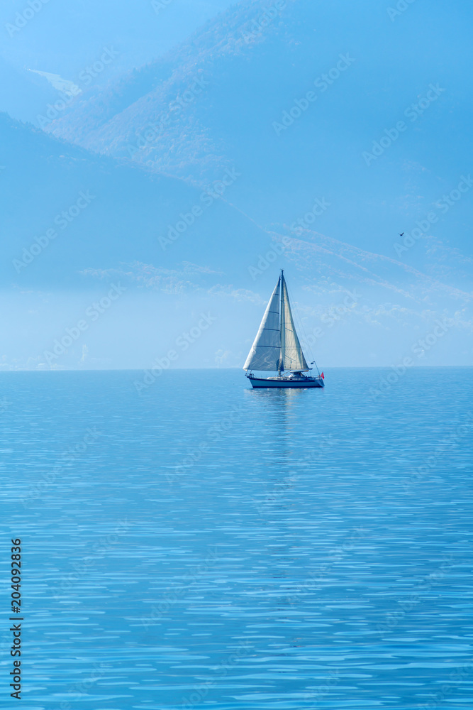Obraz premium A small sailing yacht on the Lake Geneva and the Alps, Switzerland