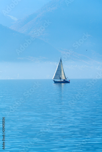 A small sailing yacht on the Lake Geneva and the Alps, Switzerland