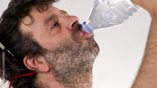 Man drinks from a plastic bottle of water. photo