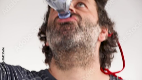 Man drinks from a plastic bottle of water. photo