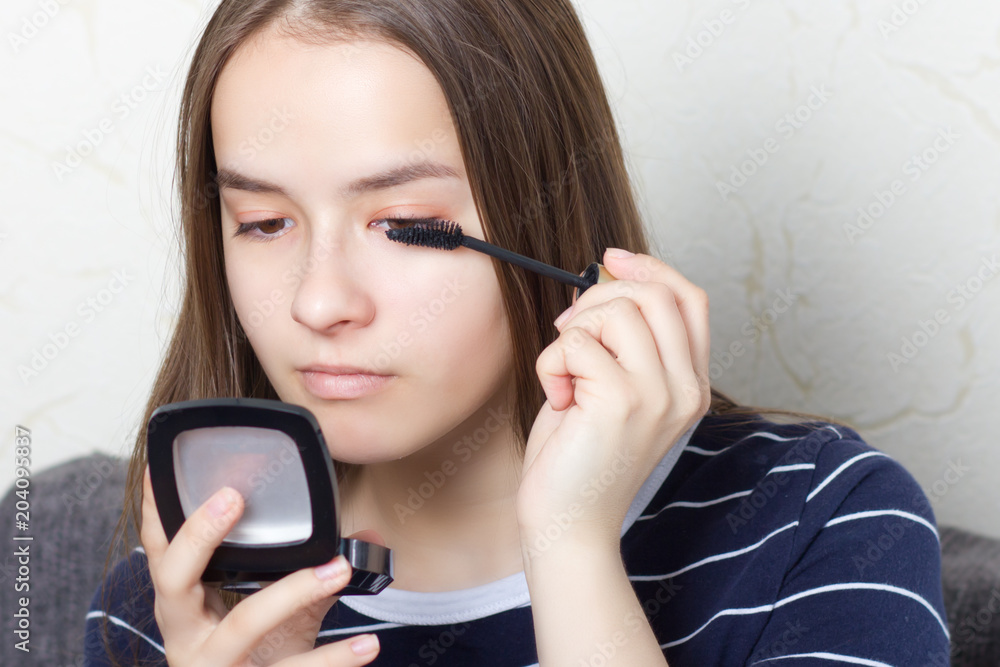 young teen girl does a natural makeup before going to a party or a walk, paints eyebrows, eyelashes young teen girl does a natural makeup before going to a party or a walk, paints eyebrows, eyelashes