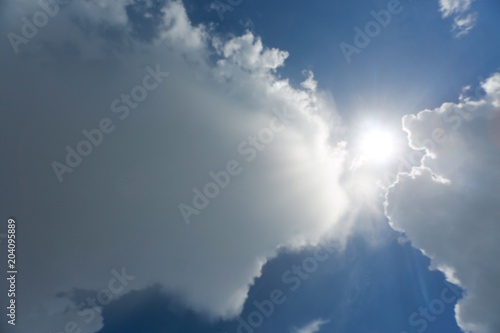 Fluffy Billowy Cumulus Clouds Revealing the Gleaming Sun in the Blue Summer Sky in Florida © kthx1138