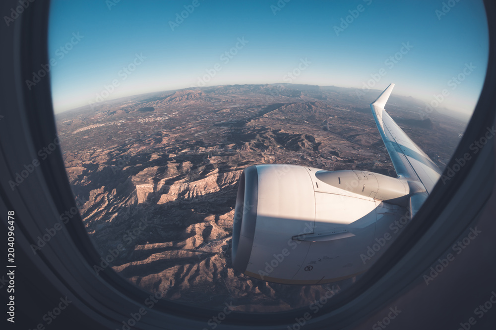 Mountainous window seat view from airplane