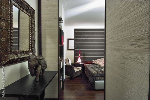 interiors shots of a ethnic bedroom in the foreground the sculpture of a elephant on the background the bed photo