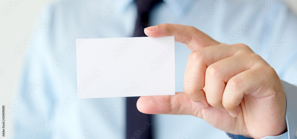 Businessman hand holding blank white business card with copy space for text, business mock up background concept Businessman hand holding blank white business card with copy space for text, business mock up background concept