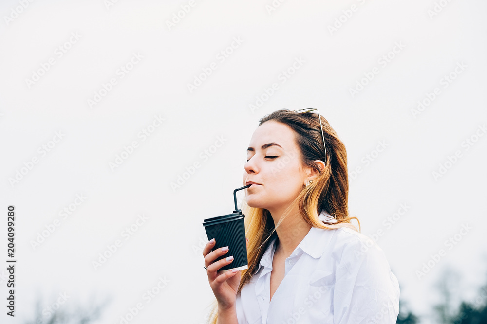a pretty girl drinking a cocktail, smiling, eyes closed, copy space a pretty girl drinking a cocktail, smiling, eyes closed, copy space