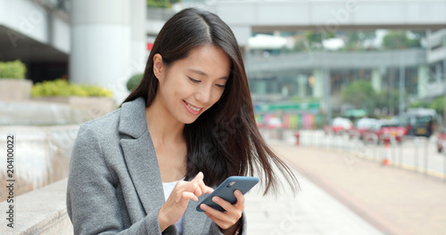 Businesswoman use of smart phone in city