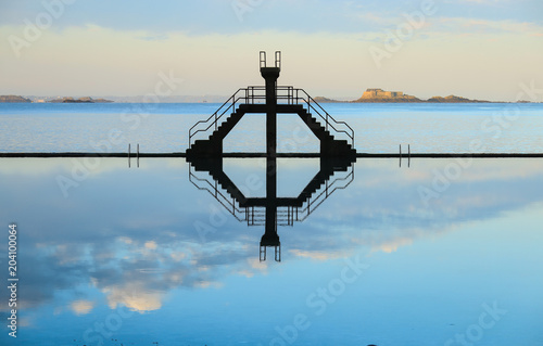 Diving board reflection on sea water swimming pool in Saint Malo, France