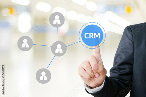 Businessman hand touch CRM, Customer Relationship Management, icon over blur background, success in business concept