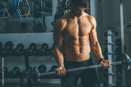 Strong and handsome young man doing exercise with dumbbells