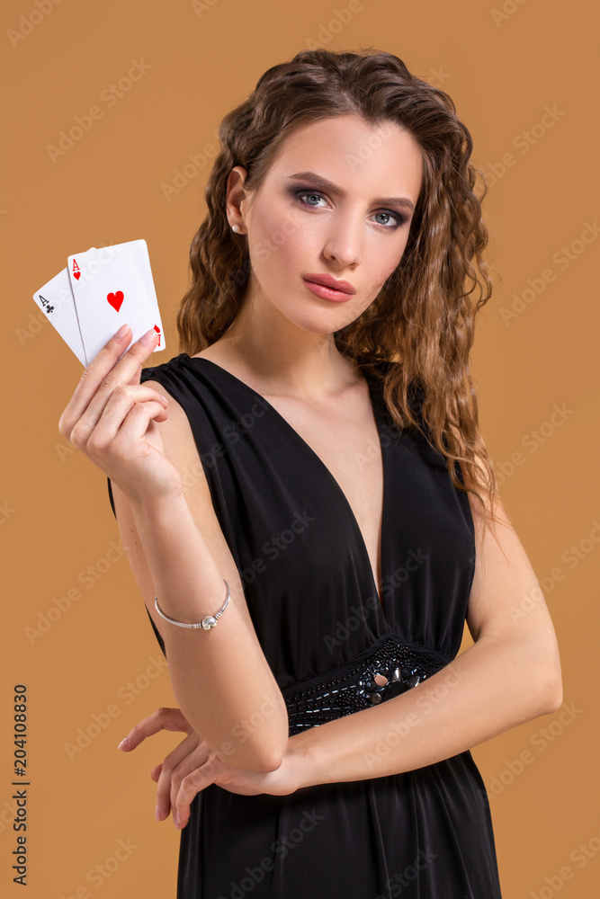 Beautiful brown-haired woman holding two aces as a sign for poker game, gambling and casino Beautiful brown-haired woman holding two aces as a sign for poker game, gambling and casino