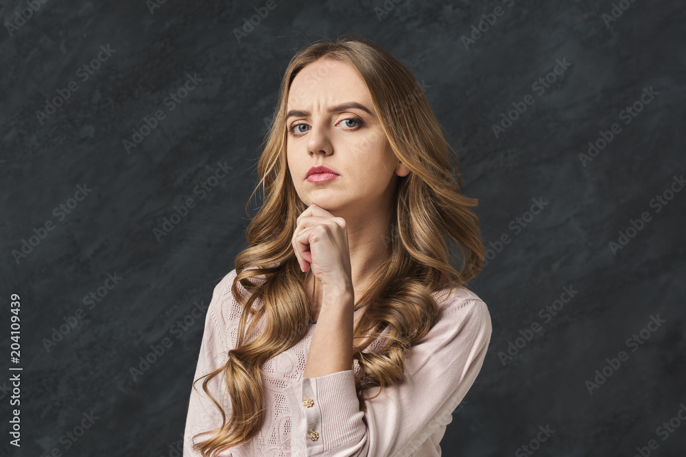 Pensive woman touching her chin, copy space Pensive woman touching her chin, copy space