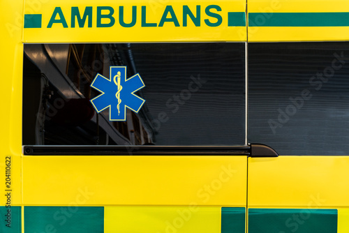 CLose up side view of a yellow and green Swedish ambulance vehicle.