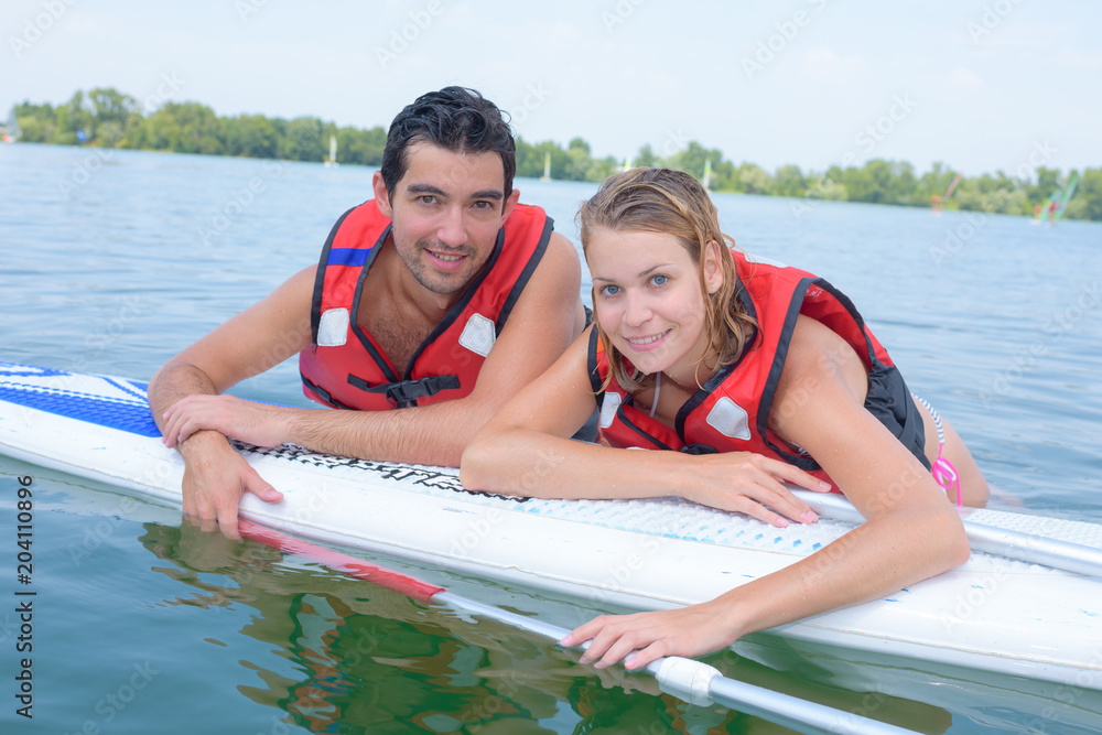 Obraz premium Couple leaning on board in water