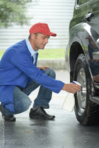 car wash worker spraying the tire © auremar