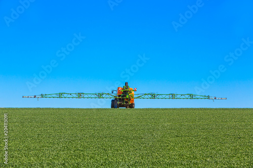 Traktor besprüht junges Feld mit Glyphosat