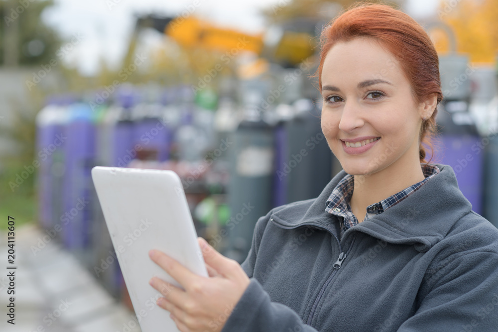 smiling young worker using tablet pc outside her office