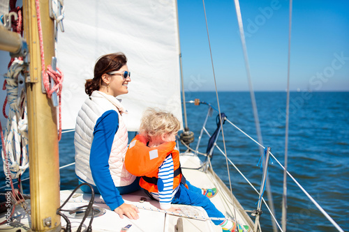 Family sailing. Mother and child on sea sail yacht.