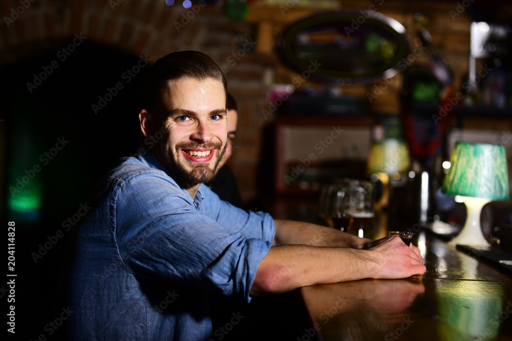 Guy with shot or liqueur sitting at bar counter.