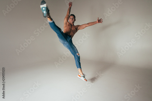 shot of mad, crazy, cheerful, successful, lucky guy in casual outfit, jeans, jumping with hands up,triumphant, gesturing against white background