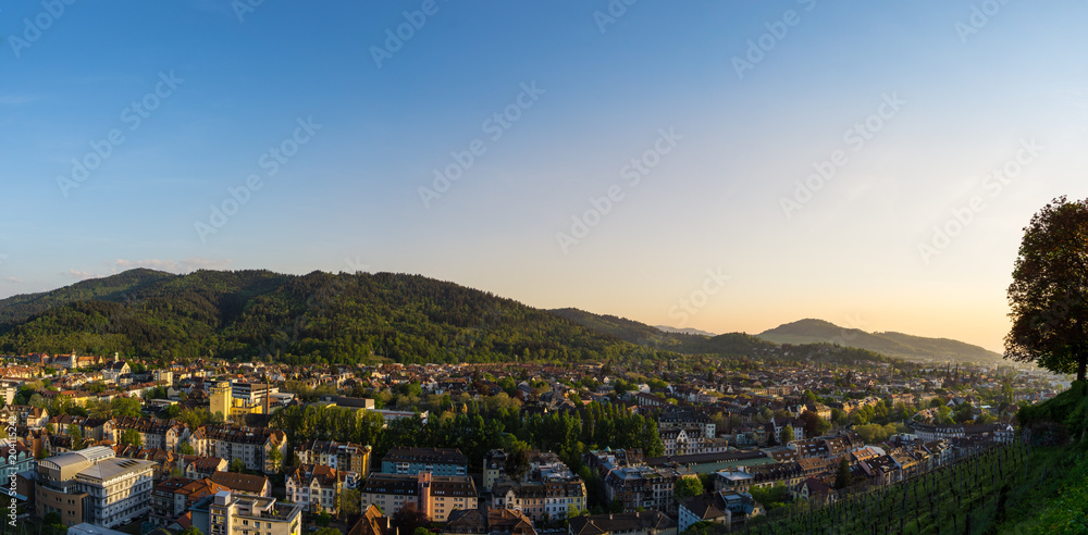 Germany, XXL panorama of city Freiburg im Breisgau at dawn in warm sunset light
