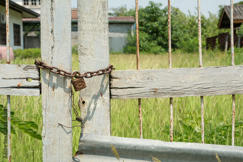 Closed meadow field gate with rusty chain Closed meadow field gate with rusty chain