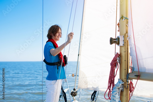 Young man sailing. Teenager boy on sea sail boat.