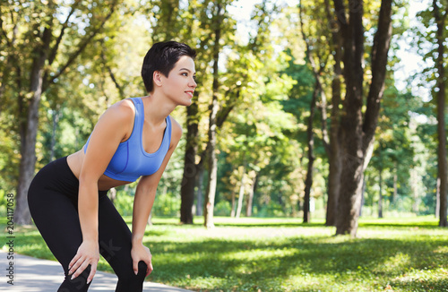 Tired woman runner breathing, taking run break