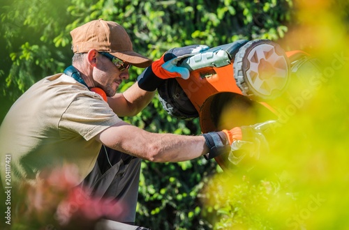 Obraz na plátně Men Fixing Lawn Mower