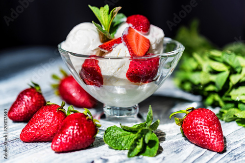 Strawberry ice cream in bowl and strawberries