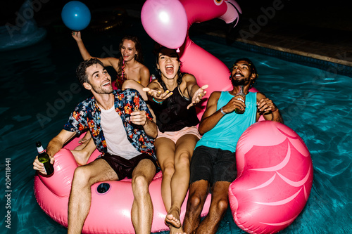 Group of friends partying in the swimming pool