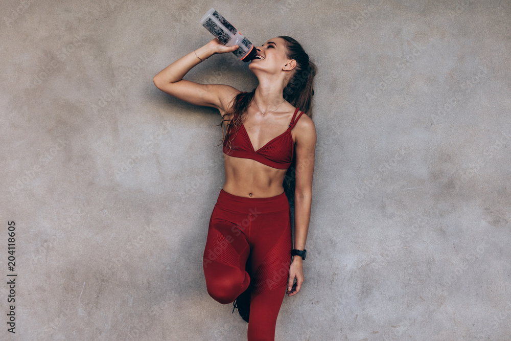 Fototapeta Female athlete drinking water