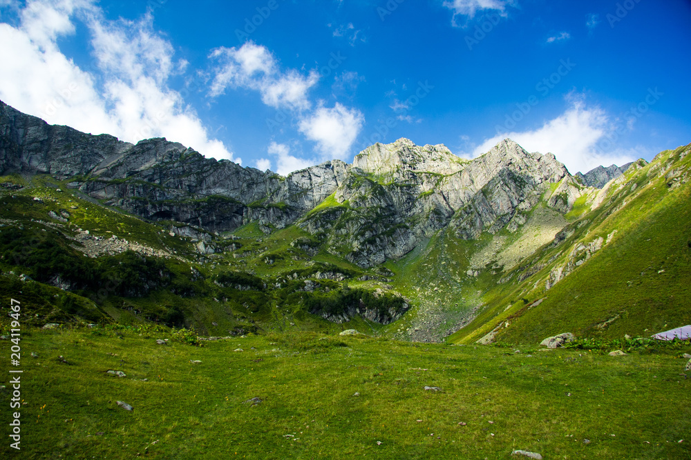 Caucasian Mountain landscape. Alpine meadow and cliffs in summer day