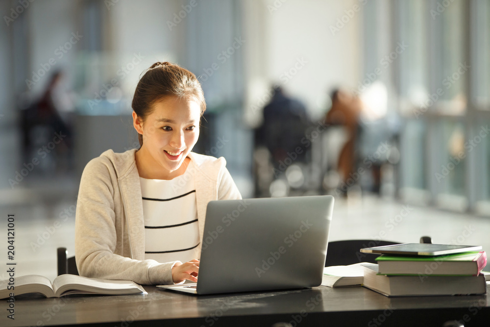 College student using a laptop while sitting in a classroom College student using a laptop while sitting in a classroom